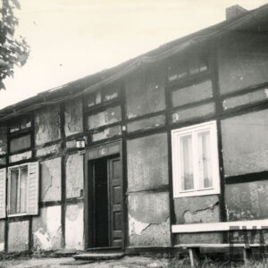 jednokondygnacyjny dom z poddaszem o konstrukcji drewnianej, z odchodzącym tynkiem