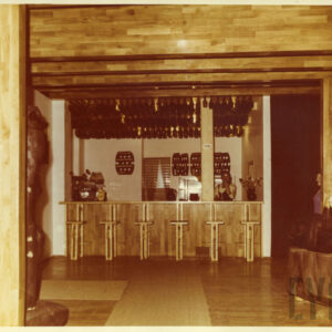 wnętrze kawiarni o charakterze ludowym wykończone drewnem, z drewnianym barem i meblami z jasnego drewna