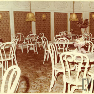 wnętrz kawiarni z białymi stolikami i giętymi, białymi krzesłami, ściany obite wzorzystym materiałem