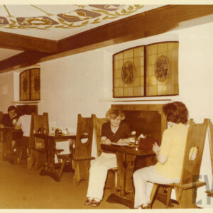 wnętrze kawiarni z drewnianymi, stylizowanymi na ludowe meblami i malowanym w ludowe wzory sufitem