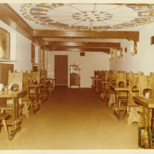 wnętrze kawiarni z drewnianymi, stylizowanymi na ludowe meblami i malowanym w ludowe wzory sufitem