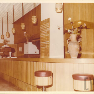 wnętrze restauracji z drewnianym barem i barowymi krzesłami w formie beczek 