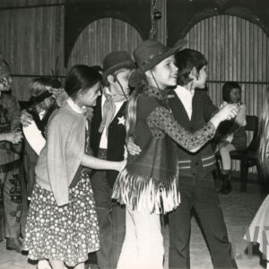 dzieci w przebraniach tańczą w parach na sali