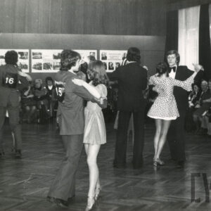 tańczące pary, wokół nich na krzesłach widownia