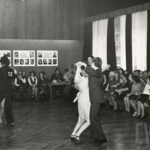 tańczące pary, wokół nich na krzesłach widownia