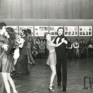 tańczące pary, wokół nich na krzesłach widownia