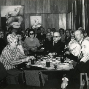 starsze osoby siedzą po kilka osób przy niskich stolikach