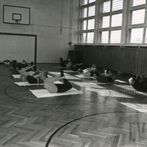 grupa ludzi ćwicząca w sali gimnastycznej