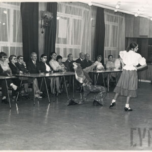 grupa seniorów siedzi przy stolikach pod oknem, ogląda przygotowany występ