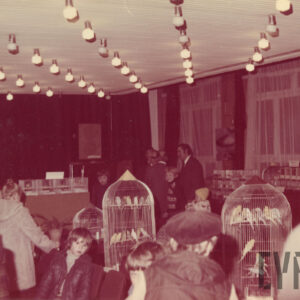 zwiedzający, głównie dzieci, oglądają ptaki w klatkach