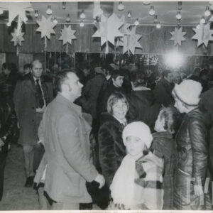 duża grupa ludzi w zimowych ubraniach spaceruje po dużej sali