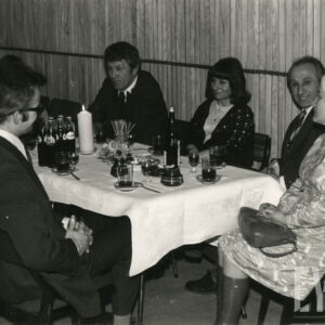 kilka kobiet i mężczyzn siedzi przy stole, na stole napoje, szklanki, świeca