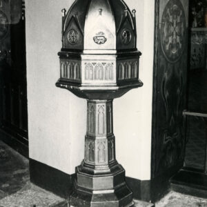 bogato zdobiona stojąca misa chrzcielna z wysokim nakryciem we wnętrzu kościoła