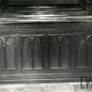 rząd zdobionych rzeźbieniami drewnianych ławek z klęcznikami w kościelnym wnętrzu