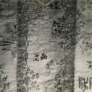 czarno-białe zdjęcie fragmentu białego ornatu w drobne, kwiatowe wzory na całej powierzchni