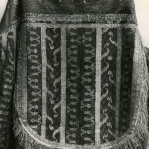 czarno-biała fotografia fragmentu wzorzystej peleryny z kapturem 