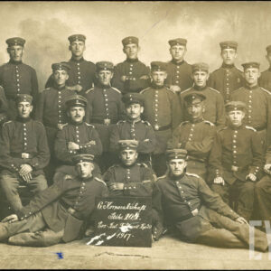 grupa mężczyzn w mundurach, dwóch z nich leży; część siedzi, część stoi