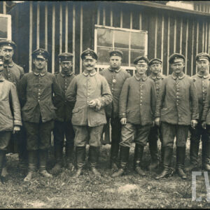 grupa mężczyzn w mundurach polowych na tle baraku