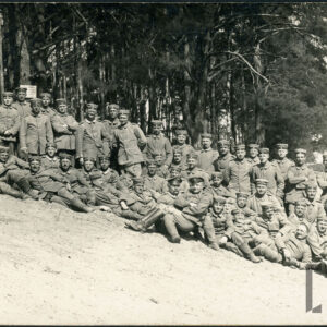 grupa kilkudziesięciu mężczyzn w mundurach polowych na piaszczystym brzegu rzeki