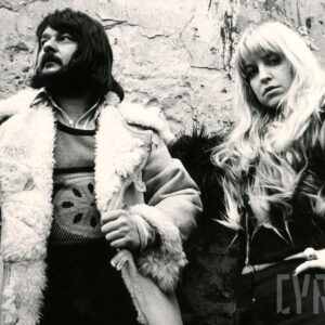 czarno-biała fotografia mężczyzny i kobiety na tle chropowatego muru