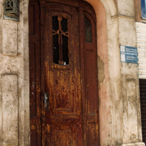 drewniane, odrapane drzwi, z lewej numer budynku