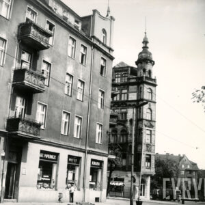 po obu stronach skrzyżowania kilkukondygnacyjne kamienice, w środku kamienica z wieżyczką