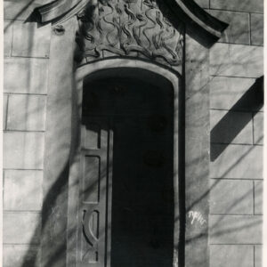 drewniane drzwi nad nimi bogata dekoracja rzeźbiarska