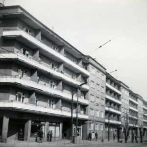 czteropiętrowe bloki z balkonami, stojące wzdłuż ulicy