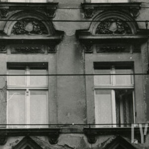 fragment elewacji z dwoma oknami i dekoracją rzeźbiarska nad nimi