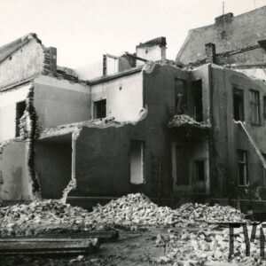 trzykondygnacyjny budynek w trakcie rozbiórki, wokół budynku gruz