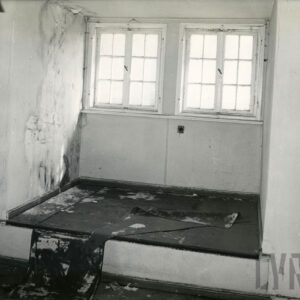 opuszczone pomieszczenie, pod oknami podest, zabrudzenia na podłodze, oderwana wykładzina podłogowa