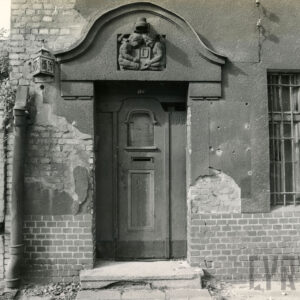 drewniane drzwi nad nimi bogata dekoracja rzeźbiarska