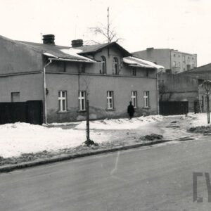 dwukondygnacyjny budynek ze skośnym dachem, na chodniku odgarnięty śnieg