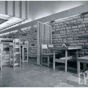 wnętrze baru z drewnianymi, prostymi meblami i ścianami wyłożonymi nieregularnymi, kamiennymi płytkami