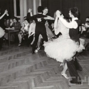 tańczące na parkiecie pary, dookoła nich siedzi publiczność