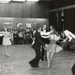 tańczące na parkiecie pary, dookoła nich siedzi publiczność