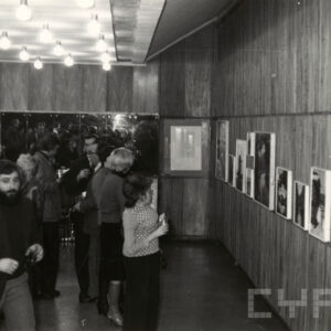 ludzie oglądający obrazy powieszone na ścianach