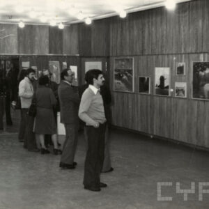 ludzie oglądający obrazy powieszone na ścianach