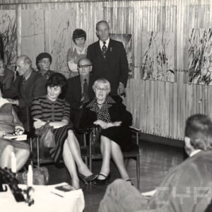 grupa ludzi siedzi na krzesłach w pomieszczeniu