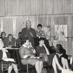 grupa ludzi siedzi na krzesłach w pomieszczeniu