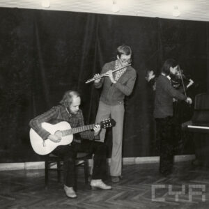 trzech mężczyzn na scenie gra na instrumentach muzycznych