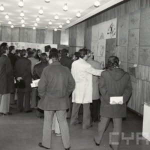 grupa ludzi oglądających powieszone na ścianie projekty