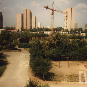 plac zabaw, na drugim planie dźwig budowlany, w głębi wieżowce