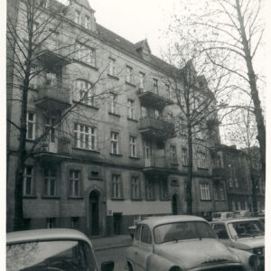 trzypiętrowa kamienica z suteryną, mieszkalnym poddaszem, na pierwszym planie zaparkowane samochody