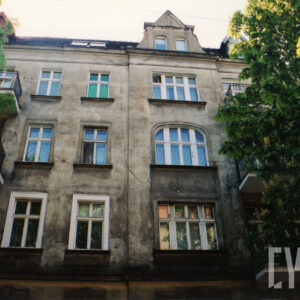 fragment elewacji kamienicy z trzema kondygnacjami i mieszkalnym poddaszem