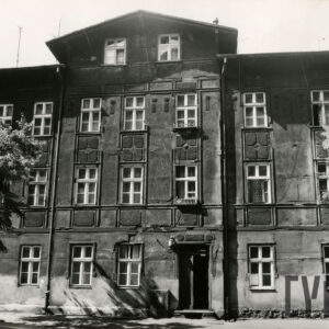 dwupiętrowa kamienica z mieszkalnym poddaszem, przed budynkiem drzewa