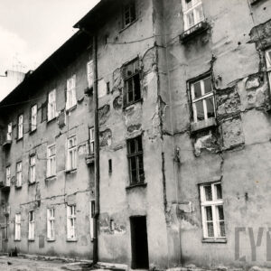 zaniedbana, z odpadającym tynkiem elewacja budynku