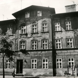 dwupiętrowa kamienica z mieszkalnym poddaszem, przed budynkiem drzewa