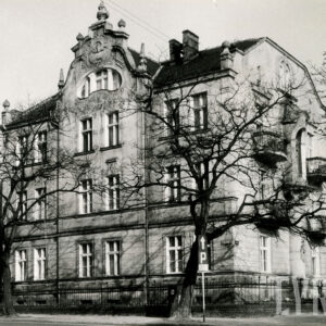 dwupiętrowa willa z suteryną, strychem i bogato zdobioną dekoracją rzeźbiarską, stoi w małym ogrodzie otoczonym metalowym płotem, przed nią drzewa