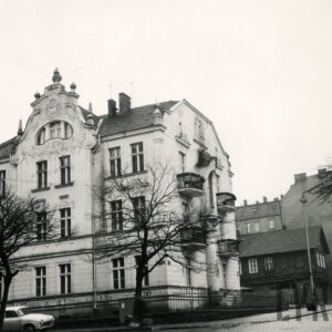 dwupiętrowa willa z suteryną i strychem bogato zdobioną dekoracją rzeźbiarską, stoi w małym ogrodzie otoczonym metalowym płotem, przed nią drzewa